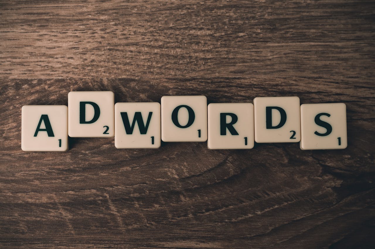 services-01 Scrabble tiles spelling 'AdWords' on a wooden surface, symbolizing digital marketing concepts.